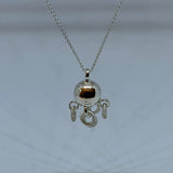 Komsekula i silver med fem små ringar. Diameter 10 mm. Silverkedja i silver 45 cm. Komsekulan är ett samiskt kultursmycke. Finns hos Risjfells Sameslöjd, Vilhelmina i södra Lappland