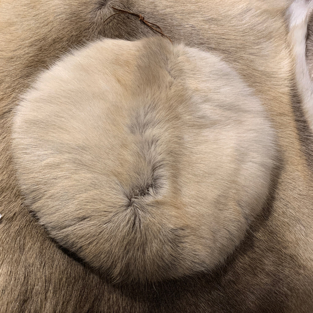 Sittlappar i garvat och tvättat renskinn. Runda i formen diameter på undersidan 33 cm. En läderrem sitter som upphängningsanordning. Risfjells Sameslöjd i Vilhelmina. 