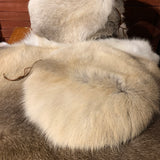 Sittlappar i garvat och tvättat renskinn. Runda i formen diameter på undersidan 33 cm. En läderrem sitter som upphängningsanordning. Risfjells Sameslöjd i Vilhelmina södra Lappland. 