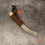 En sydsamisk halvhornskniv i mindre modell med sydsamisk gravyr av Same/Duodjislöjdare Sven-Åke Risfjell från Vilhelmina i Södra Lappland. Knivens hela längd i hölstret är 20 cm. Knivskaftet och hölstret är i renhorn. Det smidda bladets längd är 62 mm. Knivens upphängningsanordning är i tvinnat renskinn. Risfjells Sameslöjd i Vilhelmina södra Lappland.