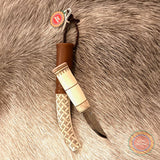 En sydsamisk halvhornskniv i mindre modell med sydsamisk gravyr av Same/Duodjislöjdare Sven-Åke Risfjell från Vilhelmina i Södra Lappland. Knivens hela längd i hölstret är 20 cm. Knivskaftet och hölstret är i renhorn. Det smidda bladets längd är 62 mm. Knivens upphängningsanordning är i tvinnat renskinn. Risfjells Sameslöjd i Vilhelmina södra Lappland.