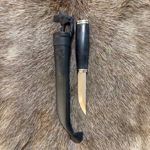 Jakt och fiskekniv i björk med mörkbrun infärgning och nitad metalltopp. Den är 26 cm lång i hölstret och knivbladet blankpolerat mäter 90 mm. Ej Risfjelltillverkad men finns i vårt utbud i vår butik Risfjells Sameslöjd i Vilhelmina södra Lappland.