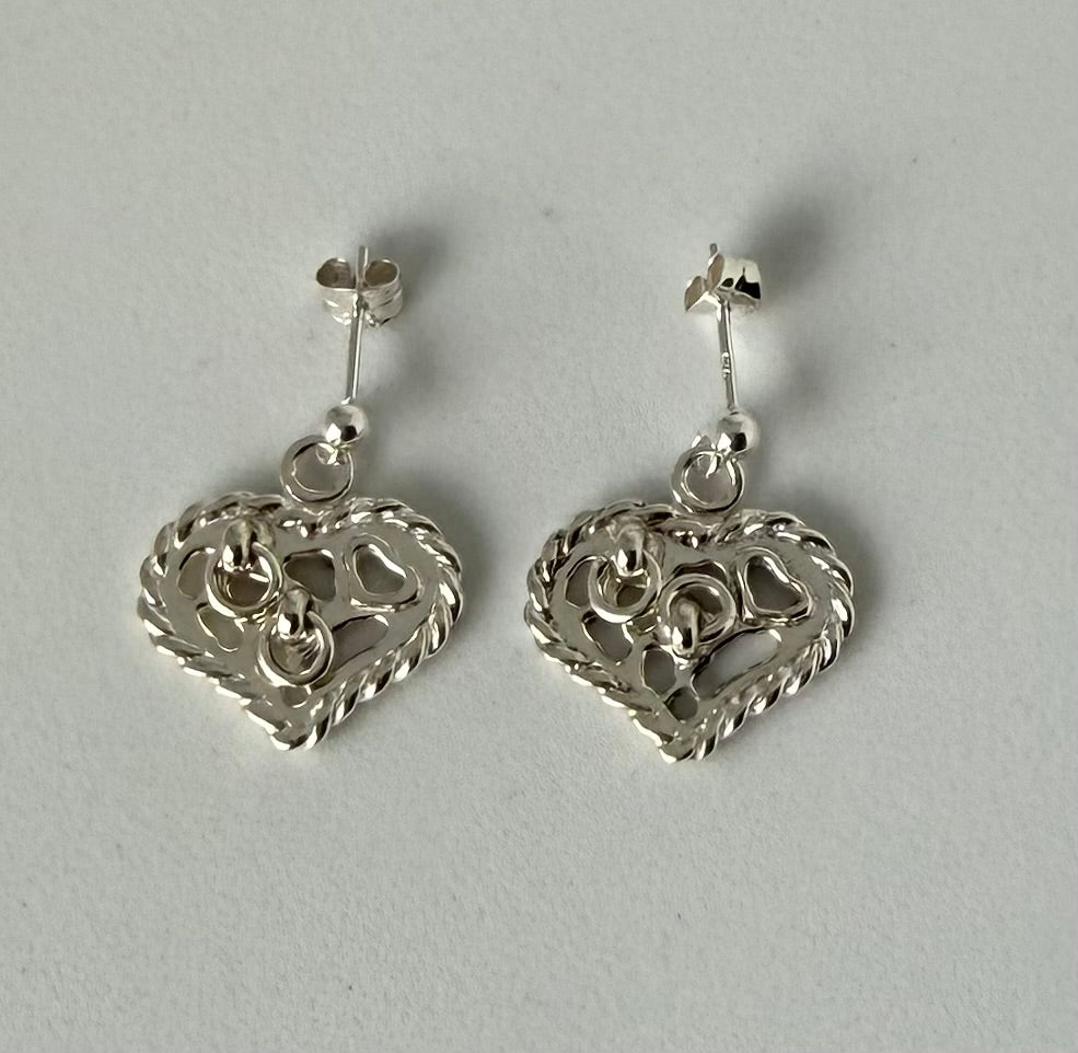 Kärleksörhänget i silver i hjärtats form där varje örhänge är dekorerat med två små ringar. Stift.