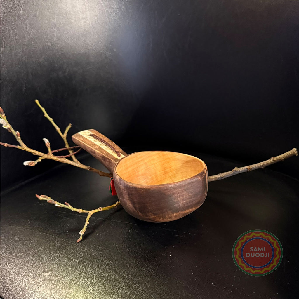 Kåsa ur björkvril med horninlägg och sydsamisk mönstergravyr av Duodji sameslöjdare Sven-Åke Risfjell Vilhelmina. Kåsans längd är 17cm och diameter 9,2 cm. Höjden på kåsan är 5,3 cm. Den rymmer 1,5-2 dl Risfjells Sameslöjd Vilhelmina i södra Lappland