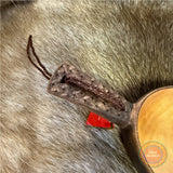 Kåsa ur björkvril med riklig karvsnittsgravyr med sydsamiskt mönster på skaftets under och ovansida&nbsp; och undersidan av skålen på kåsan. Tillverkad av same/Duodjislöjdare Sven-Åke Risfjell. Kåsan rymmer lite drygt 1,5 dl. Koppens diameter 8,5 cm. Kåsans längd är 15,5 cm. Djup 3,5 cm. Tvinnad rem av renskinn med tofs i kläde i rött och grönt. Risfjells Sameslöjd i Vilhelmina, södra Lappland