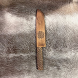 Kockkniv i björk med karvsnittsgravyr av same-Duodjislöjdare Sven-Åke Risfjell, Vilhelmina. Knivens längd i hölstret är 40,5cm lång inne i hölstret. Knivbladet är japanskt smide 22 cm. Japanskt tunt blad. Risfjells Sameslöjd i Vilhelmina 