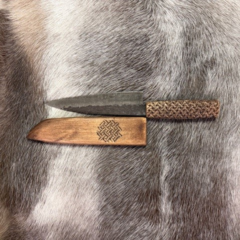 Kockkniv i björk med karvsnittsgravyr av same-Duodjislöjdare Sven-Åke Risfjell, Vilhelmina. Knivens längd i hölstret är 40,5cm lång inne i hölstret. Knivbladet är japanskt smide 22 cm. Japanskt tunt blad. Risfjells Sameslöjd i Vilhelmina 