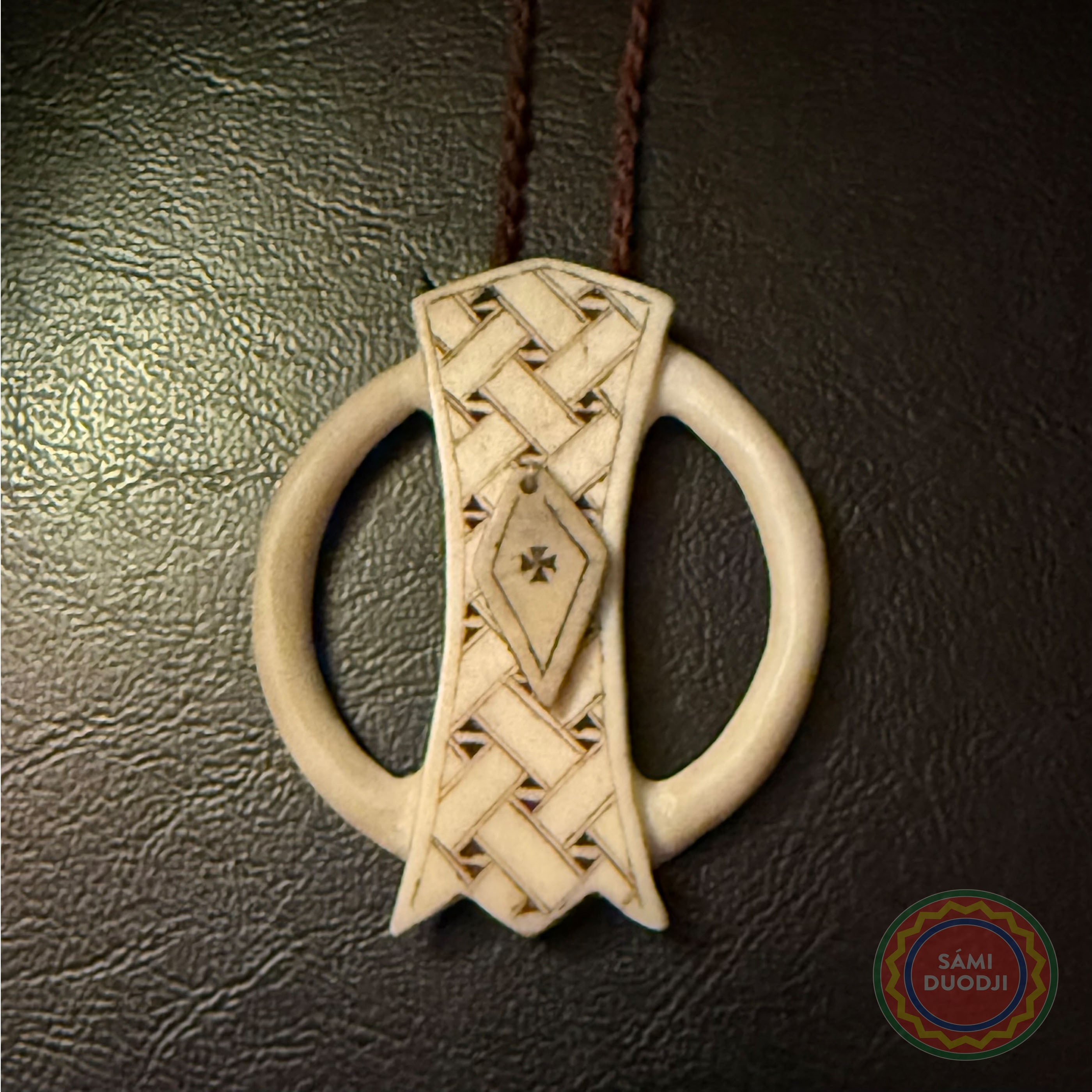 Malja unikt i horn, Mariasmycket i Sven-Åke Risfjells egen design. Maljan är ett av de äldsta samiska kultursmyckena som vanligtvis är gjorda i silver men här har Sven-Åke Risfjell valt att göra dem i horn. Mittpartiet är graverad med ett sydsamiskt mönster.av Sven-Åke. Halsrem i tvinnat renskinn 70 cm. Ringens diameter är 48 mm. Mittpartiets längd 55 mm.