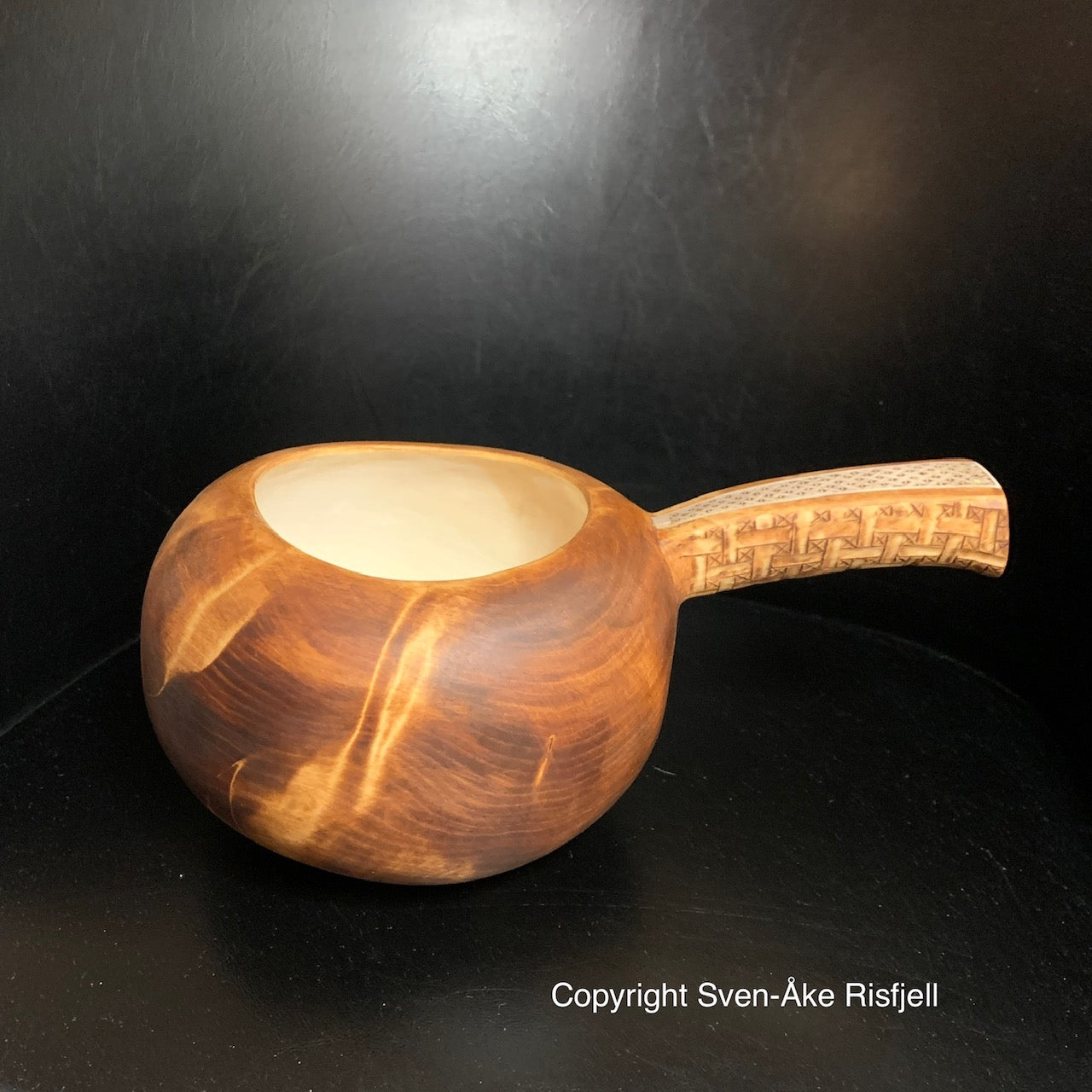 Nahpie, traditionell samisk mjölkstäva ur björkvril av Duodji-sameslöjdare Sven-Åke Risfjell.  Nahpien har horninlägg i skaftet med ett sydsamiskt flätmönster i gravyren och karvsnitt på skaftets undersida. Hel längd från handtag till själva skålens ytterkant är 25 cm. Skålens diameter är 15 cm. Risfjells Sameslöjd i Vilhelmina södra Lappland.