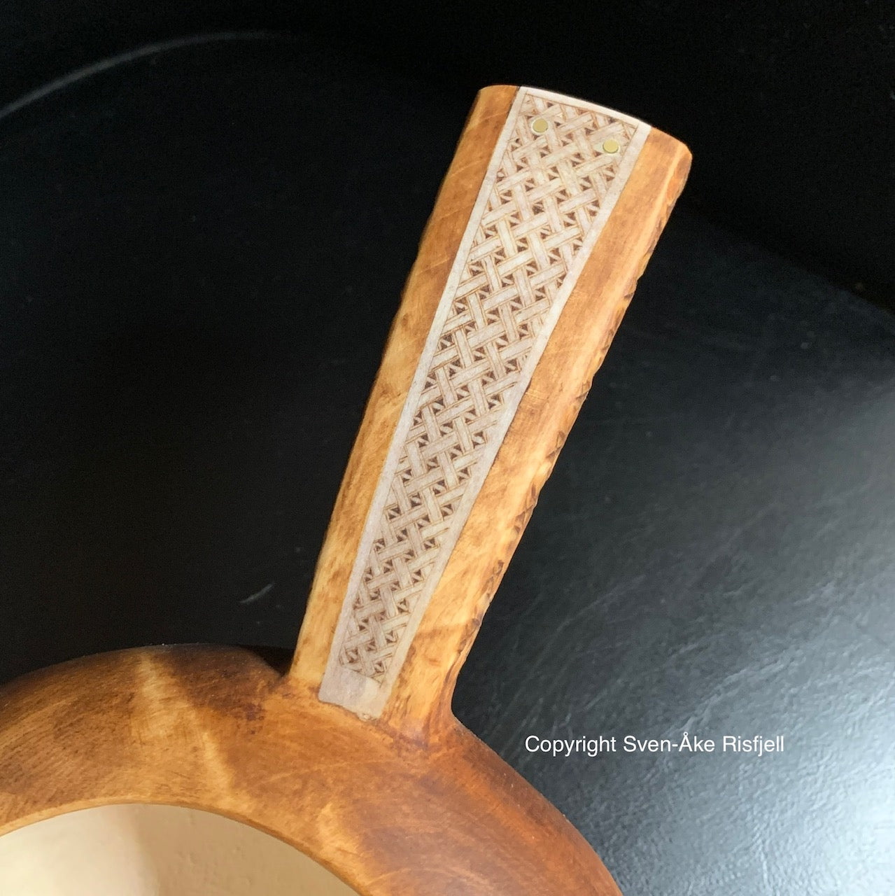 Nahpie, traditionell samisk mjölkstäva ur björkvril av Duodji-sameslöjdare Sven-Åke Risfjell.  Nahpien har horninlägg i skaftet med ett sydsamiskt flätmönster i gravyren och karvsnitt på skaftets undersida. Hel längd från handtag till själva skålens ytterkant är 25 cm. Skålens diameter är 15 cm. Risfjells Sameslöjd i Vilhelmina södra Lappland. Här ser du den sydsamiska mönstergravyren i hornet på skaftet.