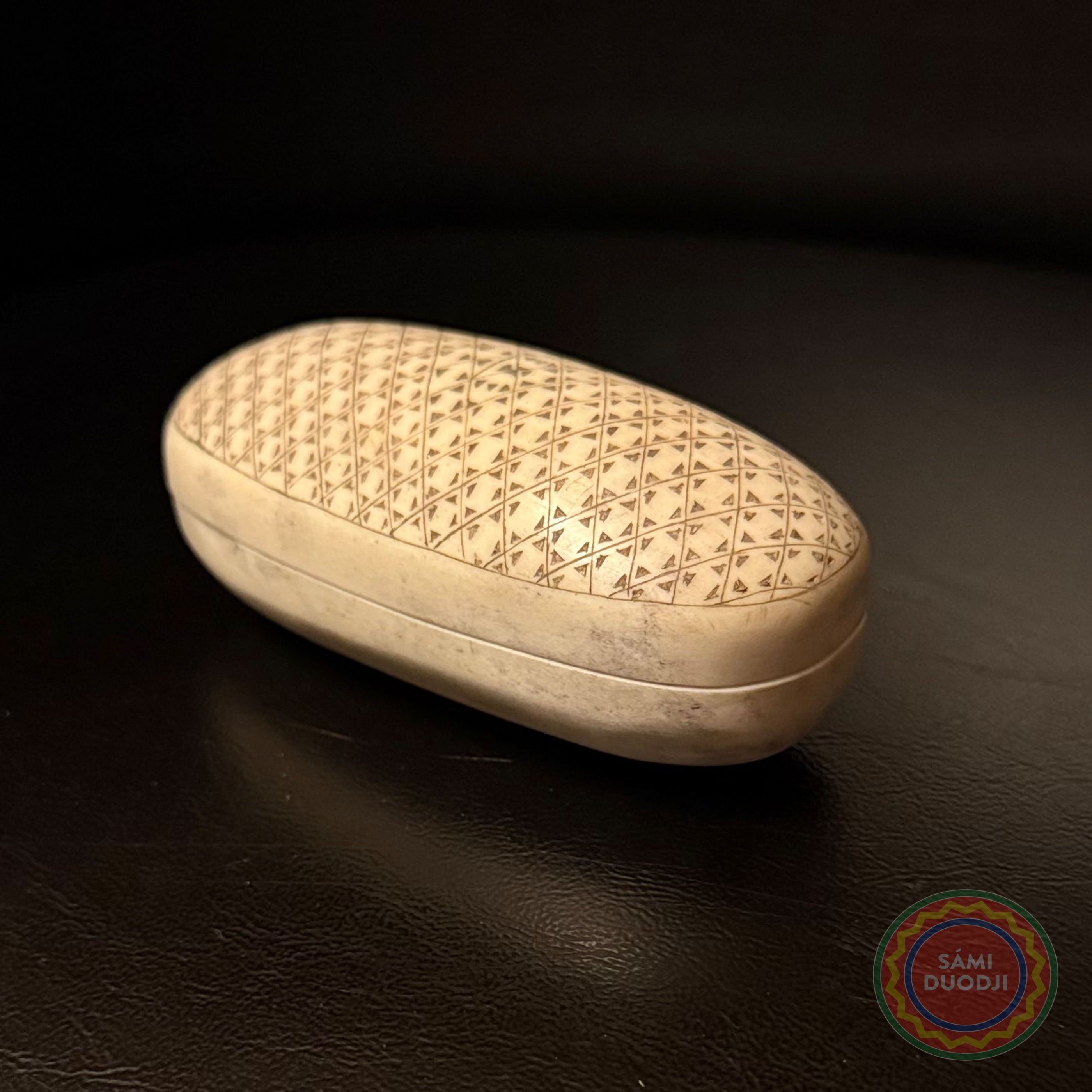 Nipperask i älghorn av Sven-Åke Risfjell Vilhelmina. Den är dekorerad med det Gamla Nåjdmönstret från Marsfjäll som Sven-Åke återupptäckt och använder i sin i gravyr. Mönstret som Sven-Åke åtrerbördat har nu blivit det 25.e mönstret i den sydsamiksa mönstersamlingen. Askens längd är längd 10 cm, bredd 4,5 cm och höjd 4 cm.