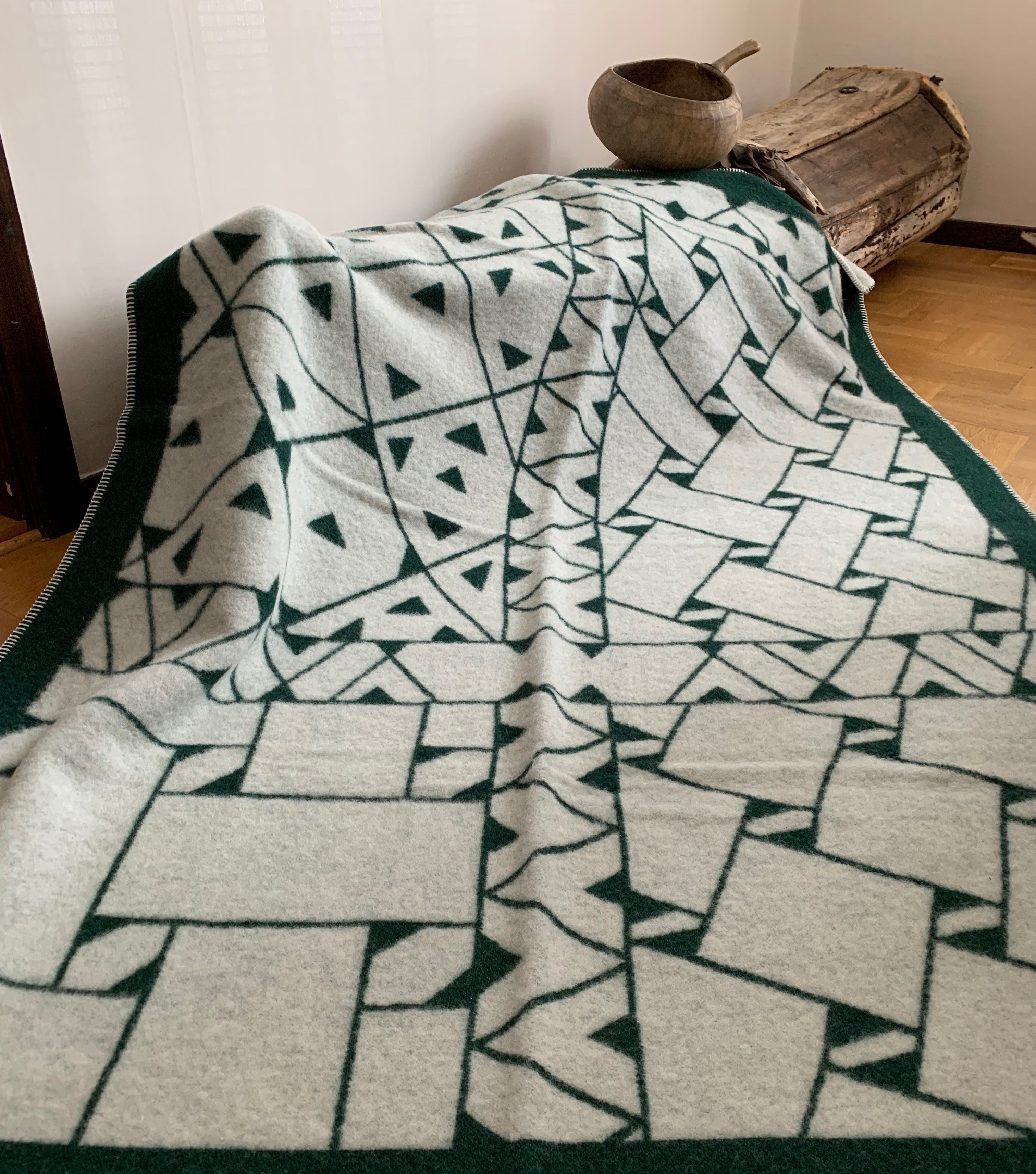 Pläd i ull. En unikt designad pläd av sameslöjdarna Doris och Sven-Åke Risfjell Vilhelmina Risfjells sameslöjd. Det gamla Nåjdmönstret från Marsfjäll återbördat i slöjden igen av Sven-Åke Risfjell och i textil produktion av Doris Risfjell. Här i grönvit färgställning.