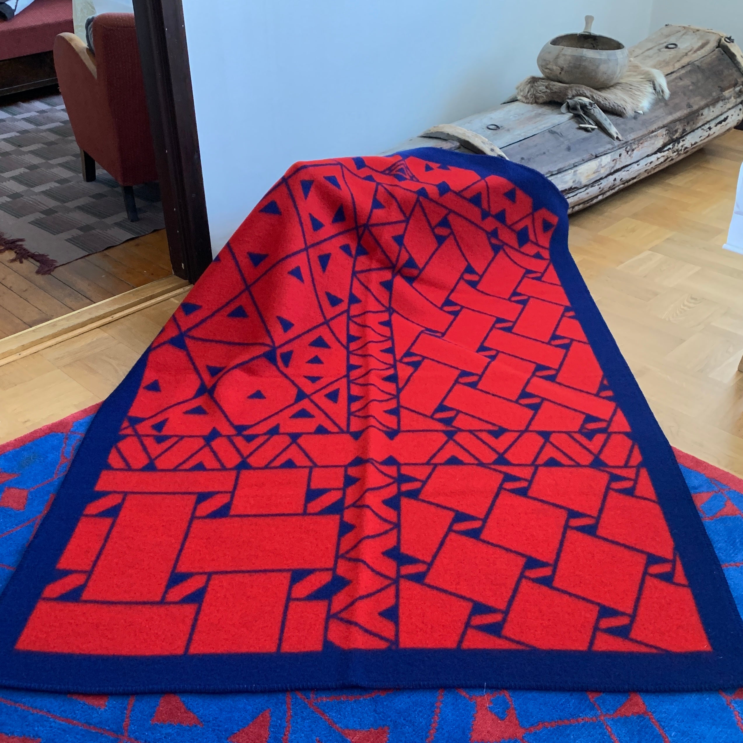 Pläd i ull. En unikt designad pläd av sameslöjdarna Doris och Sven-Åke Risfjell Vilhelmina Risfjells sameslöjd. Det gamla Nåjdmönstret från Marsfjäll återbördat i slöjden igen av Sven-Åke Risfjell och i textil produktion av Doris Risfjell. Här i blåröd-vit färgställning.