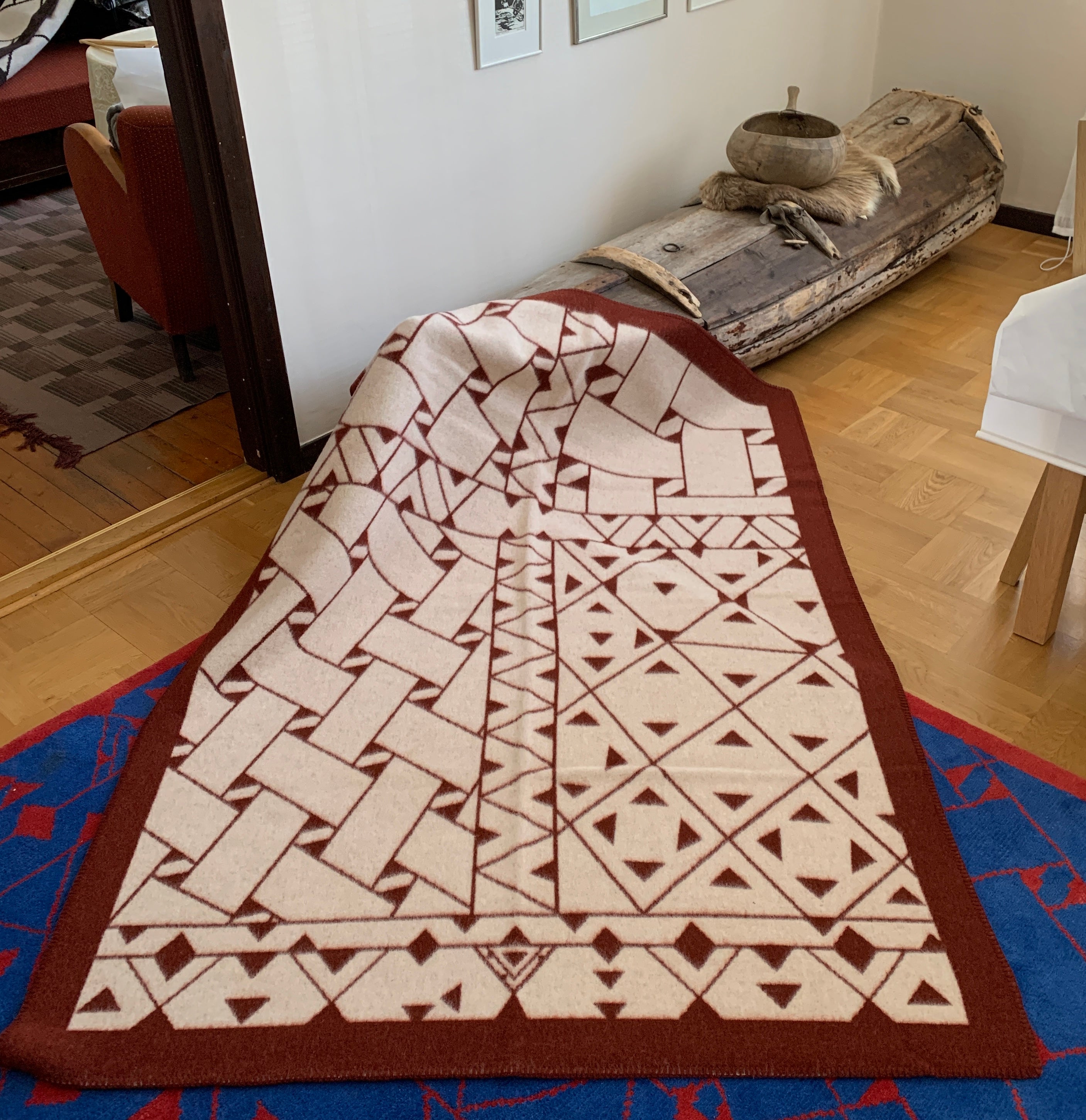 Pläd i ull. En unikt designad pläd av sameslöjdarna Doris och Sven-Åke Risfjell Vilhelmina Risfjells sameslöjd. Det gamla Nåjdmönstret från Marsfjäll återbördat i slöjden igen av Sven-Åke Risfjell och i textil produktion av Doris Risfjell. Här i brunvit färgställning.