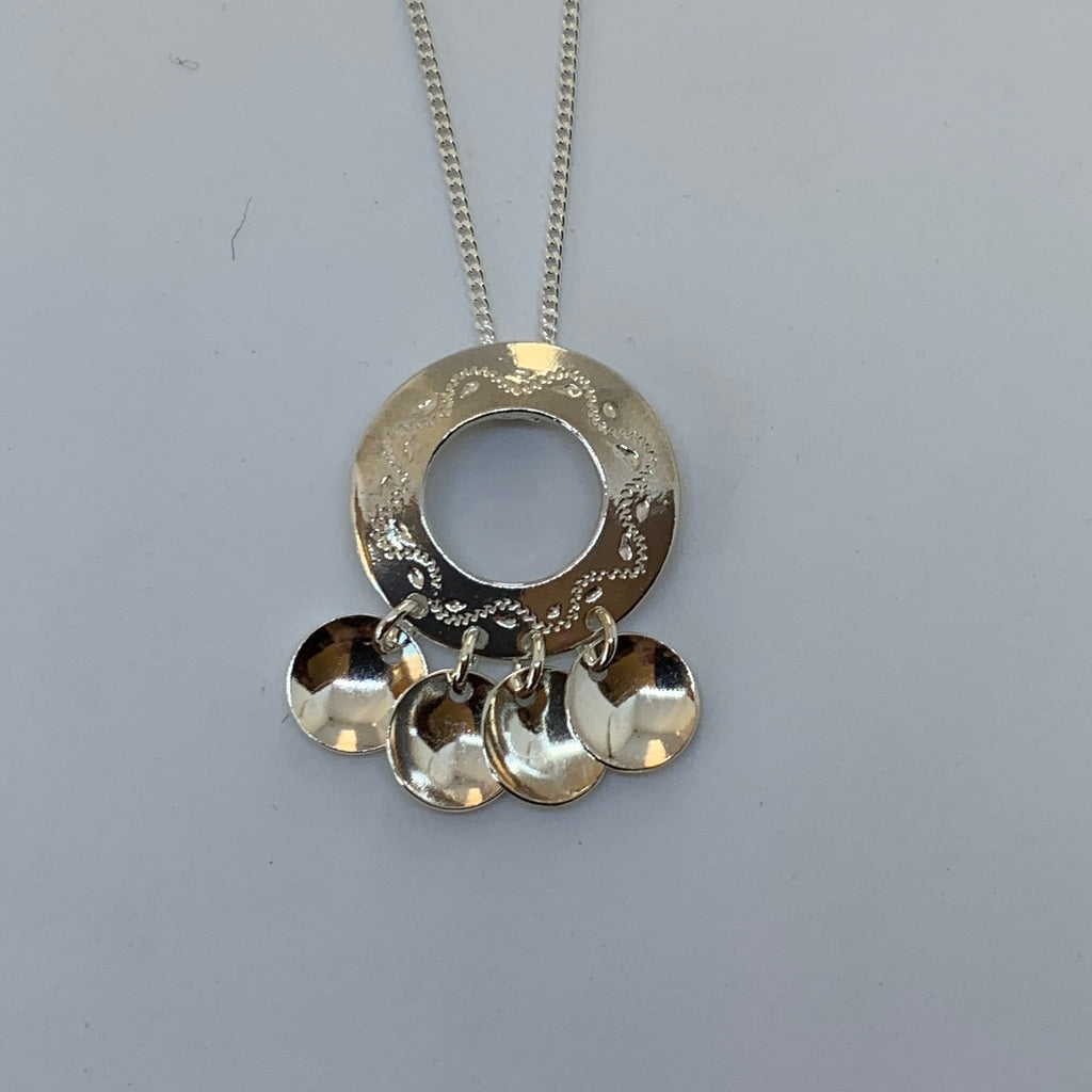 Samiskt silverhalsband Malja med fyra runda löv som djupa tallrikar. Maljan är dekorerad med en slingformad gravering. Maljans diameter är 25 mm. Smyckets längd med tallrikslöven är 35 mm. Medföljande silverkedja är 45 cm. Finns hos Risjfells Sameslöjd i Vilhelmina södra Lappland.