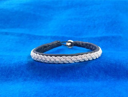 Tenntrådsarmband Fyrfläta på renskinn Samiskt hantverk av Doris Risfjell, Vilhelmina Risfjells Sameslöjd