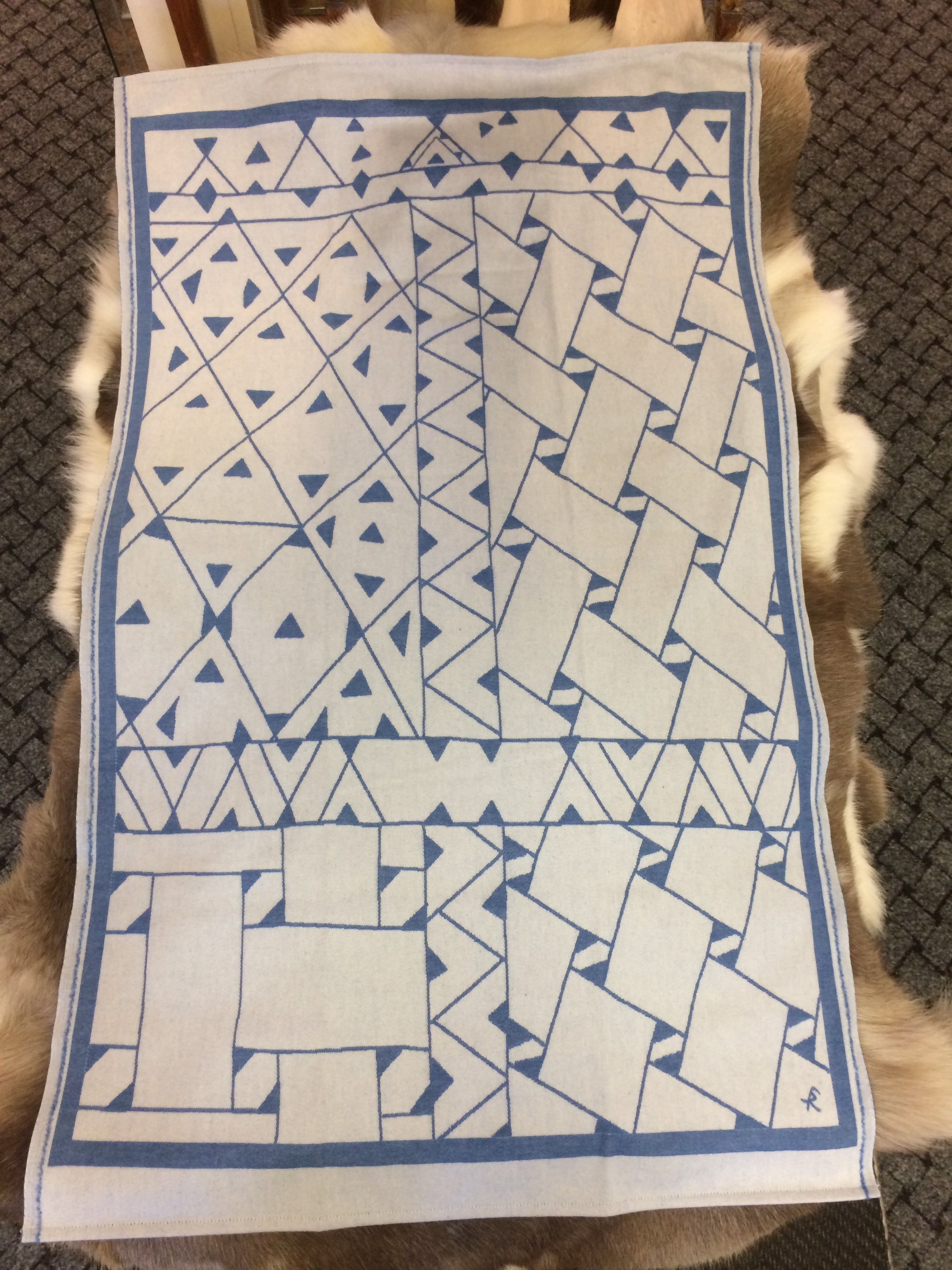 Barnfilt Marsfjällsnåjdens mönster i Doris och Sven-Åke Risfjells design,Risfjells Sameslöjd i Vilhelmina, södra Lappland. Filten i mjuk och skön bomullsflanell. Här i blått mönster från Marsfjällsnåjdens Daaskoe.