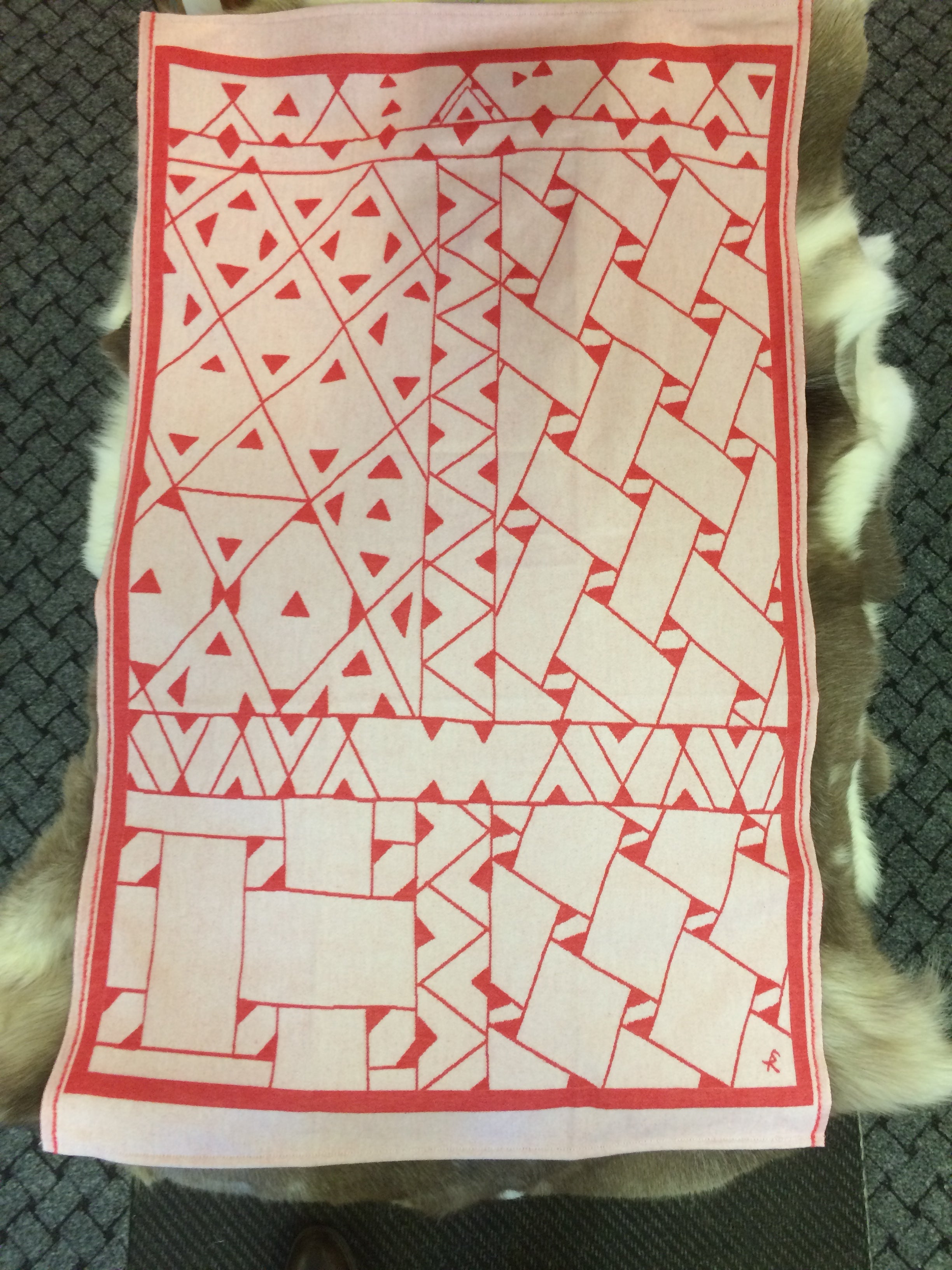 Barnfilt Marsfjällsnåjdens mönster i Doris och Sven-Åke Risfjells design,Risfjells Sameslöjd i Vilhelmina, södra Lappland. Filten i mjuk och skön bomullsflanell. Här i rött mönster från Marsfjällsnåjdens Daaskoe.