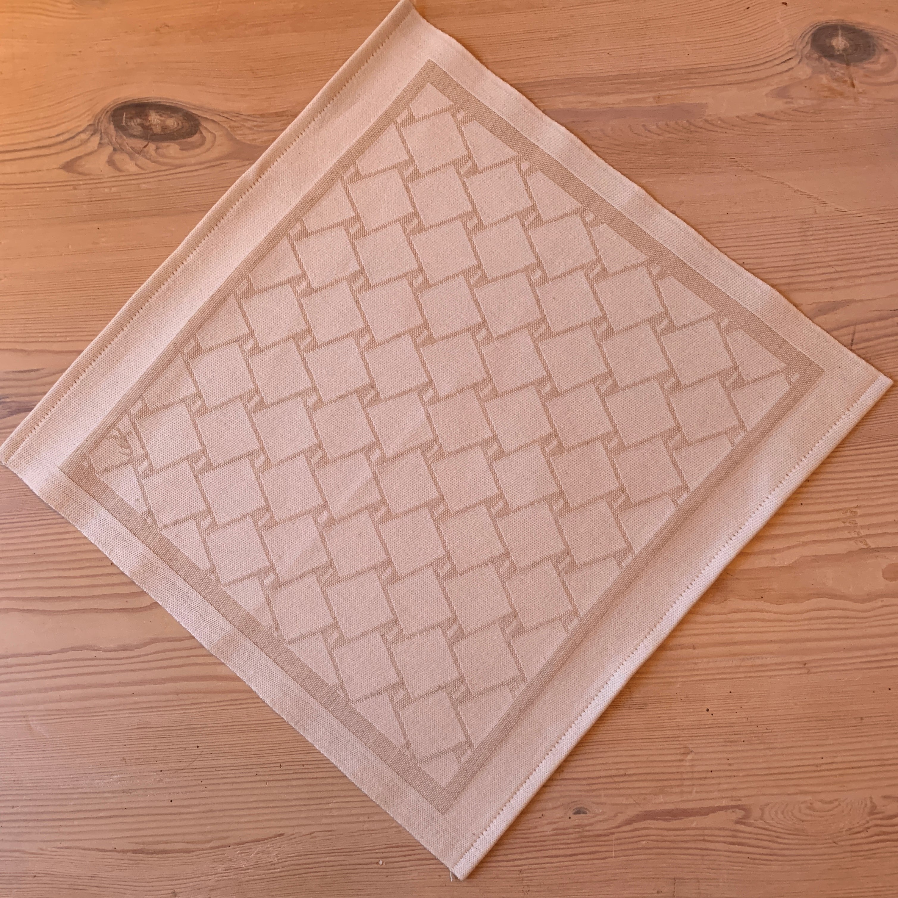 En bordstablett eller servett med nr tre av de tre sydsamiska flätmönster som går att återfinna på Marsfjällsnåjdens Daaskoe-väska som Sven-Åke Risfjell har satt ljus på i sin detaljstudie av väskan som han hittade tecknad i en bok i slutet av 1990-talet.  Här linets färg på flätan som är på vit botten.