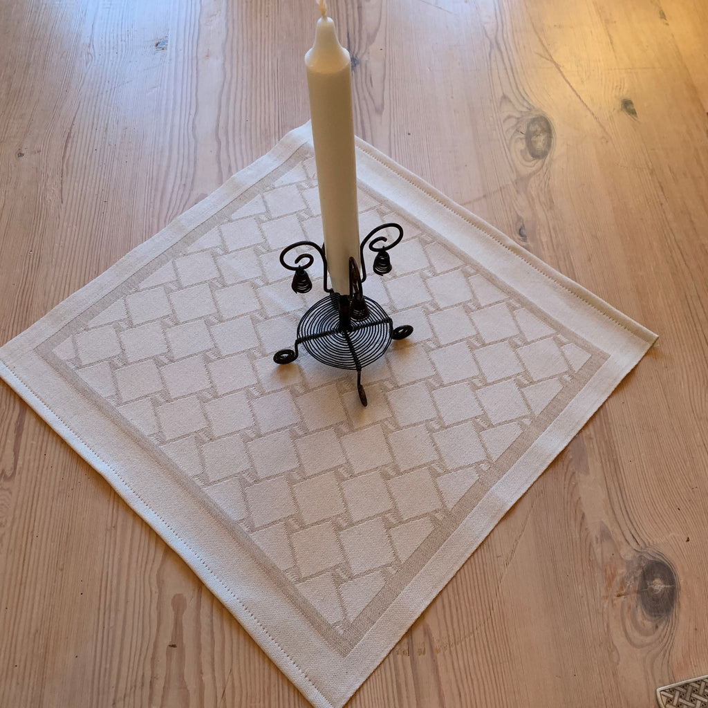 En bordstablett eller servett med nr tre av de tre sydsamiska flätmönster som går att återfinna på Marsfjällsnåjdens Daaskoe-väska som Sven-Åke Risfjell har satt ljus på i sin detaljstudie av väskan som han hittade tecknad i en bok i slutet av 1990-talet.  Här linets färg på flätan som är på vit botten.