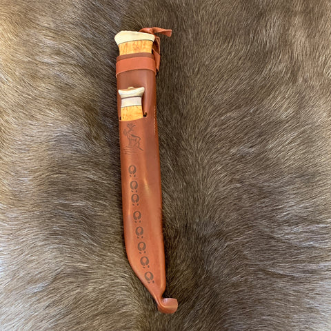 Dubbelkniv med huggare och kniv i masurbjörk (ej egen tillverkning) Den har nitad horntopp och mässingavslut på skaftet mot knivbladet. Huggarens längd i fodral är 37 cm varav knivbladet är 21 cm. Bladets bred är 38 mm. Knivens längd är 19,5 cm varav bladet är 7,7 cm. Brun läderslida med en ren som dekoration. Med knivarna på plats i slidan ger 37 cm längd. Huggaren är ett bra redskap istället för yxan och lätt att bära på bältet under tur i skog och mark. 