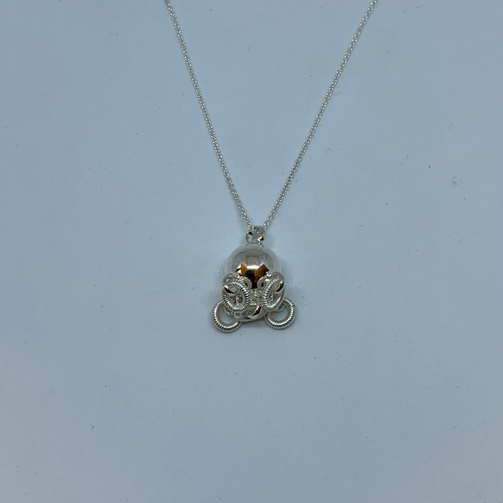 Komsekula i silver med fem små ringar. Diameter 10 mm. Silverkedja i silver 45 cm. Komsekulan är ett samiskt kultursmycke. Finns hos Risjfells Sameslöjd, Vilhelmina i södra Lappland