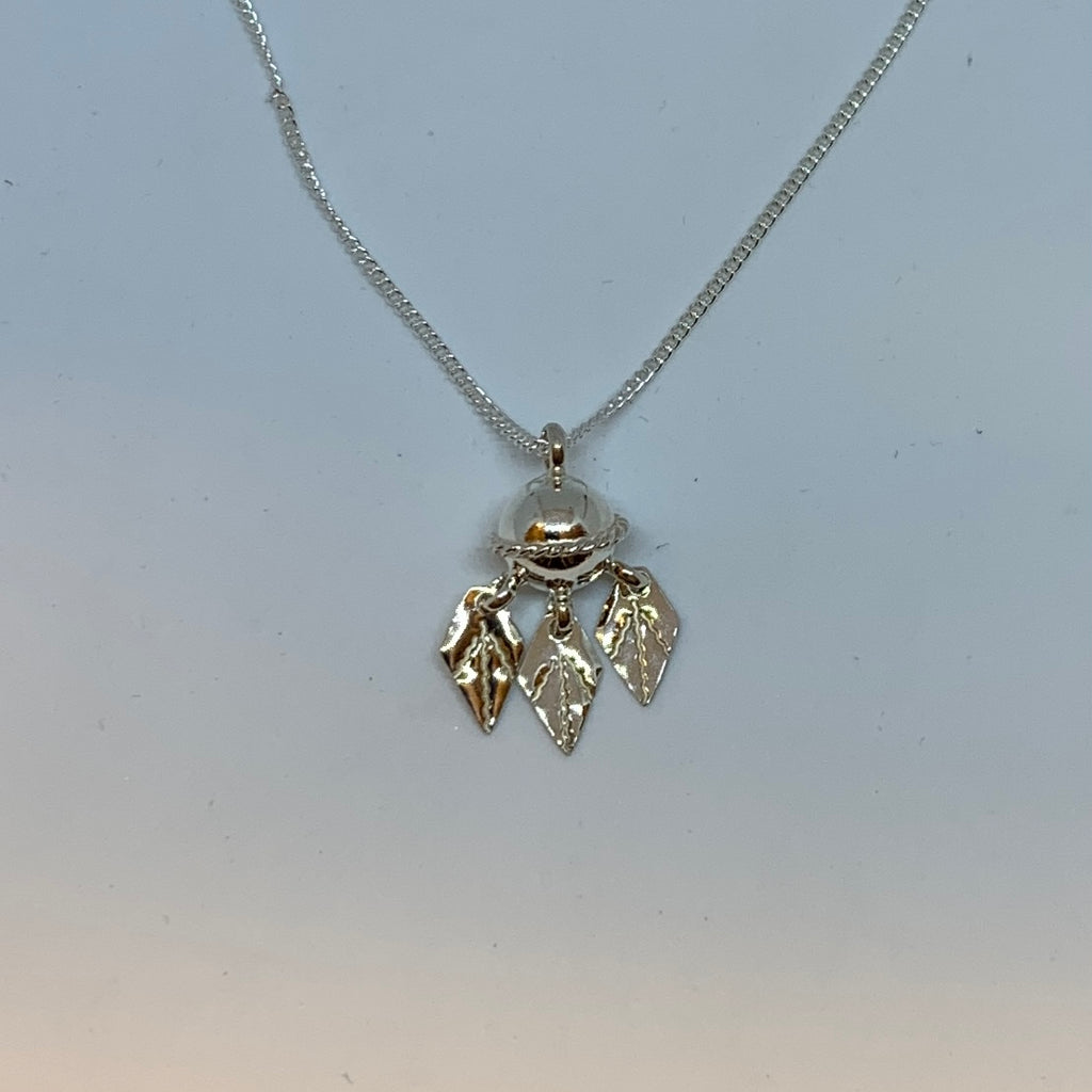 Halsband Komsekula i silver med midja och tre kråkfotslöv 10 mm. Komsekulean är ett samiskt kultursmycke. Silverkedja 45 cm. Finns hos Risfjells Sameslöjd i Vilhelmina, södra Lappland.