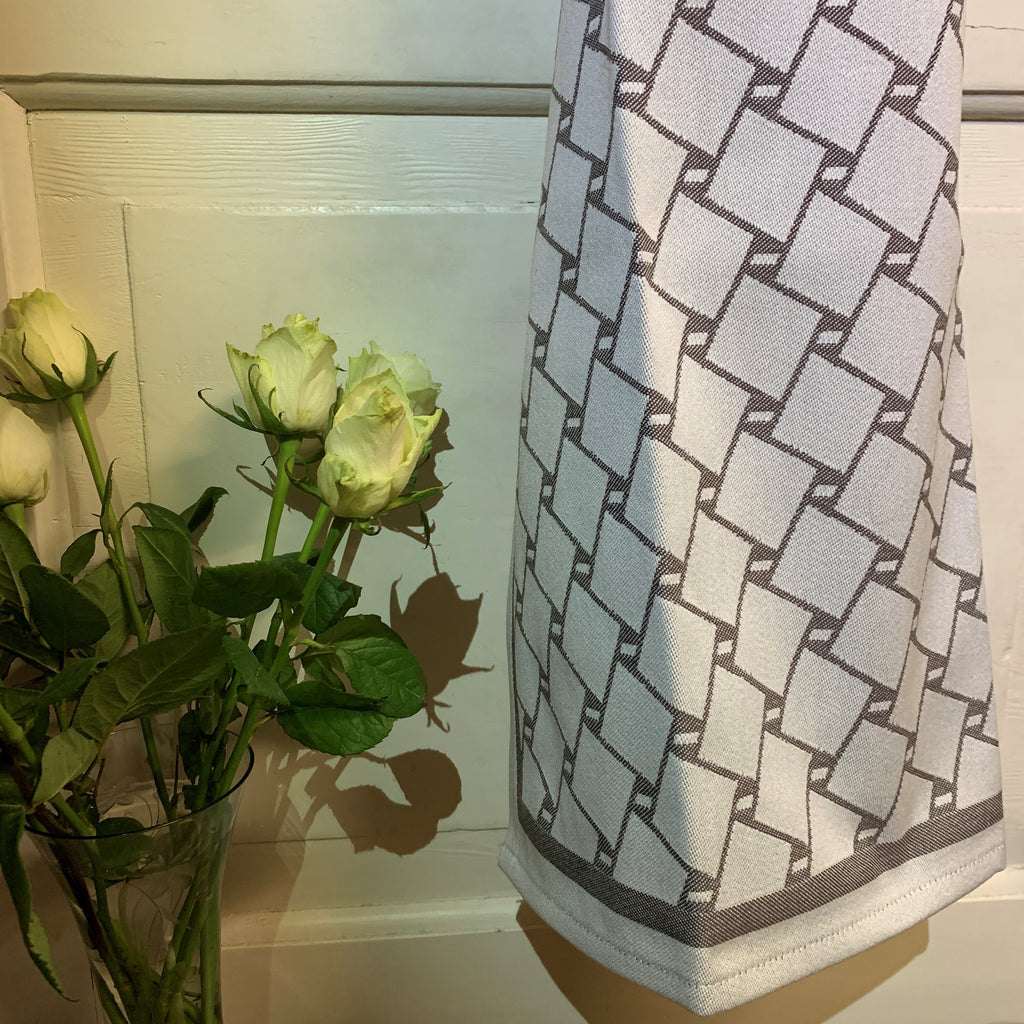 En handduk med nr tre av de tre sydsamiska flätmönster som går att återfinna på Marsfjällsnåjdens Daaskoe-väska som Sven-Åke Risfjell har satt ljus på i sin detaljstudie av väskan som han hittade tecknad i en bok i slutet av 1990-talet. Väskan är indelad i fyra fält med fyra olika mönster varav ett är helt unikt. Det gamla Nåjdmönstret är nu ett signum för Sven-Åkes slöjd där han graverar det  i olika kompositioner på sin slöjd. Doris Risfjell har i samarbete med olika väverier överfört väskans mönster till