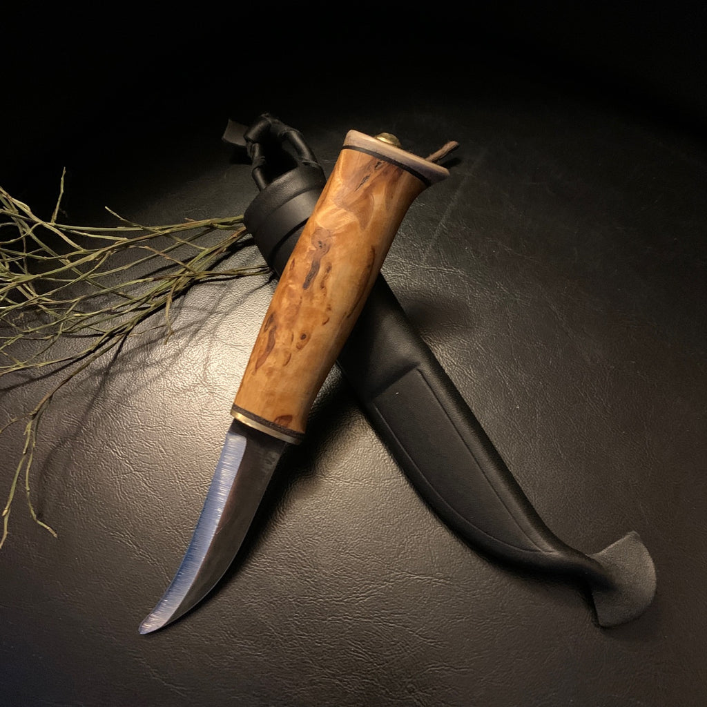 Jaktkniv buköppnare i masurbjörk och horn med böjt blad i kolstål. Bladets längd är 88 mm. Knivens längd är 18 cm. Knivens hela längd i fodral är 22 cm. Finns hos Risfjells Sameslöjd i Vilhelmina.