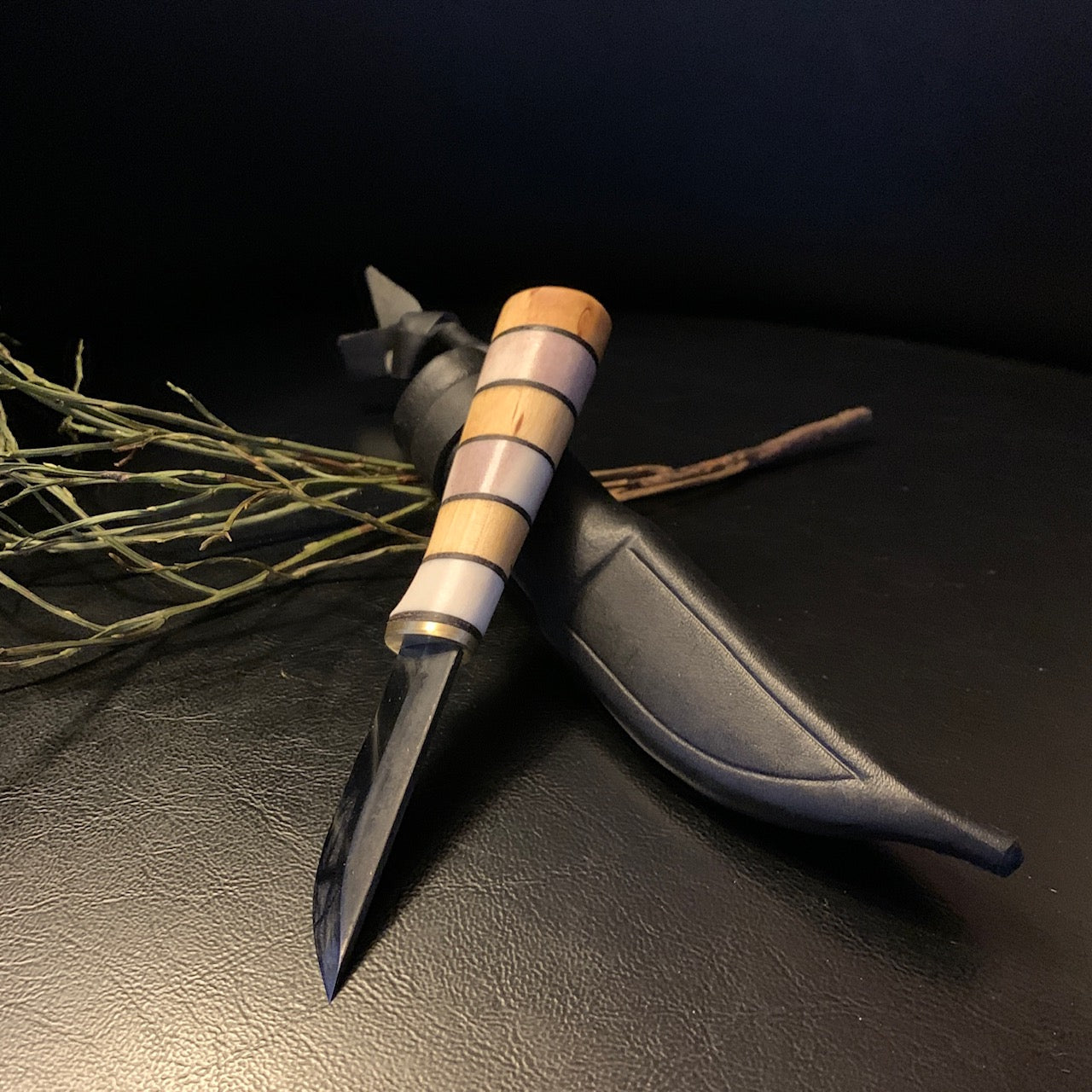 Liten kniv i björk och horn i storlek av kalvmärkarkniv. Knivens längd är12,5 cm lång varav bladet är 55 mm långt och 13 mm brett. Knivbladet är i kolstål. Knivens längd instppad i fodralet är 16,7 cm. Finns hos Risjfells Sameslöjd i Vilhelmina södra Lappland.