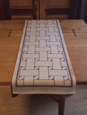 En unik produkt från oss Risfjells Sameslöjd. En löpare med nr 2 av de tre sydsamiska flätmönster som går att återfinna på Marsfjällsnåjdens Daaskoe/väska som Sven-Åke Risfjell har satt ljus på i sin detaljstudie av väskan som han såg tecknad i en bok i slutet av 1990-talet. I textil produktion av Doris Risfjell i samarbete med olika väverier.Den är gjord i bomull och lin. Bredd 38 cm. Längd 120 cm. Här i grå färgställning.    