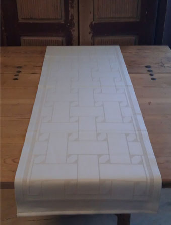 En unik produkt från oss Risfjells Sameslöjd. En löpare med nr 2 av de tre sydsamiska flätmönster som går att återfinna på Marsfjällsnåjdens Daaskoe/väska som Sven-Åke Risfjell har satt ljus på i sin detaljstudie av väskan som han såg tecknad i en bok i slutet av 1990-talet. I textil produktion av Doris Risfjell i samarbete med olika väverier.Den är gjord i bomull och lin. Bredd 38 cm. Längd 120 cm. Här i Linets färgställning.       