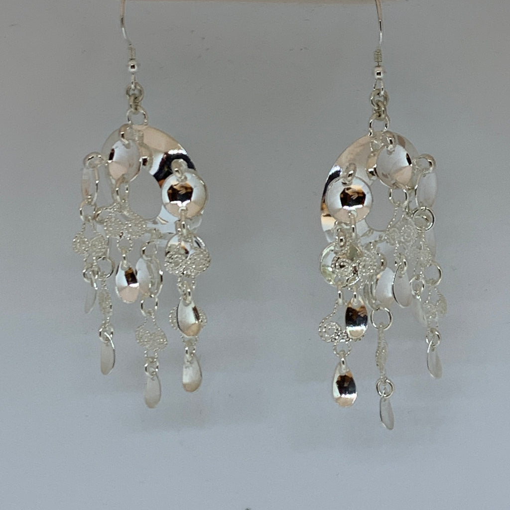 Örhängen i silver med rik samisk utsmyckning med sex rader hängen med löv, runda skålar och skedformade. Filigranarbete i hängena som små hjärtan.. Längd från krokens övre del till nedersta lövet är 75 mm, bredd 25 mm. Örhänget är inspirerat av Sven-Åke Risfjells farmor Sara Alvina Sofia Sjulsdotters brosch. Finns hos Risjfells Sameslöjd i Vilhelmina, södra Lappland.