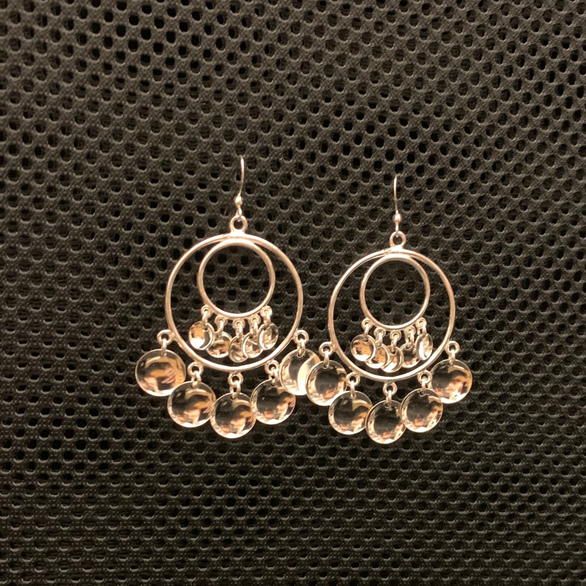 Örhängen Solbbo samisk design i silver stor modell. Diameter 32 mm. Längd 50 mm plus krok. Fem små konkava hängen i nedre kant av den stora ringen och  i mitten av ringen. sitter en mindre modell av samma smycke. Finns hos Risfjells Sameslöjd i Vilhelmina.