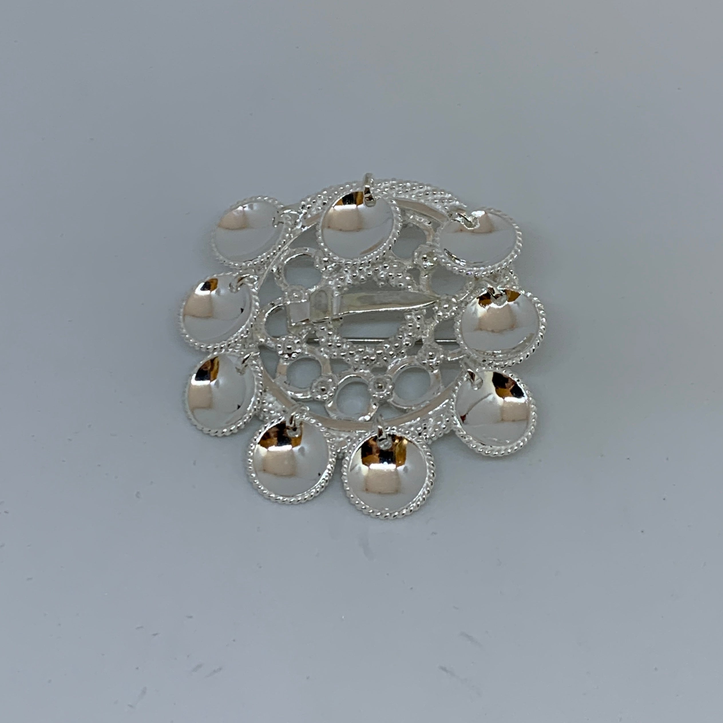 Brosch Riskuu i silver nio runda löv. Filigranarbete runt löven och hela broschets runda ring. Diameter på ringen är 4 cm. Höjd med löv är 5 cm. Finns hos Risfjells Sameslöjd i Vilhelmina, södra Lappland