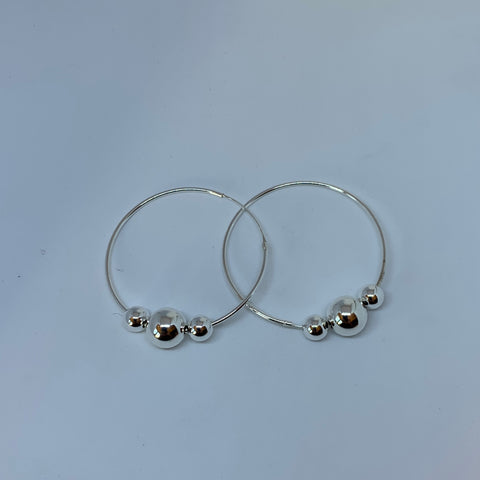 Örhängen i silver stora ringar med tre kulor. Ringens diameter är 50 cm. Stora kulan 12 mm och de mindre 8 mm i diameter. Finns hos Risfjells Sameslöjd i Vilhelmina, södra Lappland