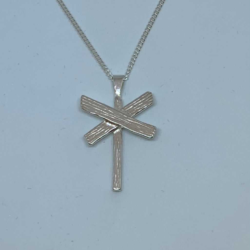 Halsband i silver i form av ett ledkryss. Längd 35 mm bredd 20 mm.Finns hos Risfjells Sameslöjd, Vilhelmina i södra Lappland.
