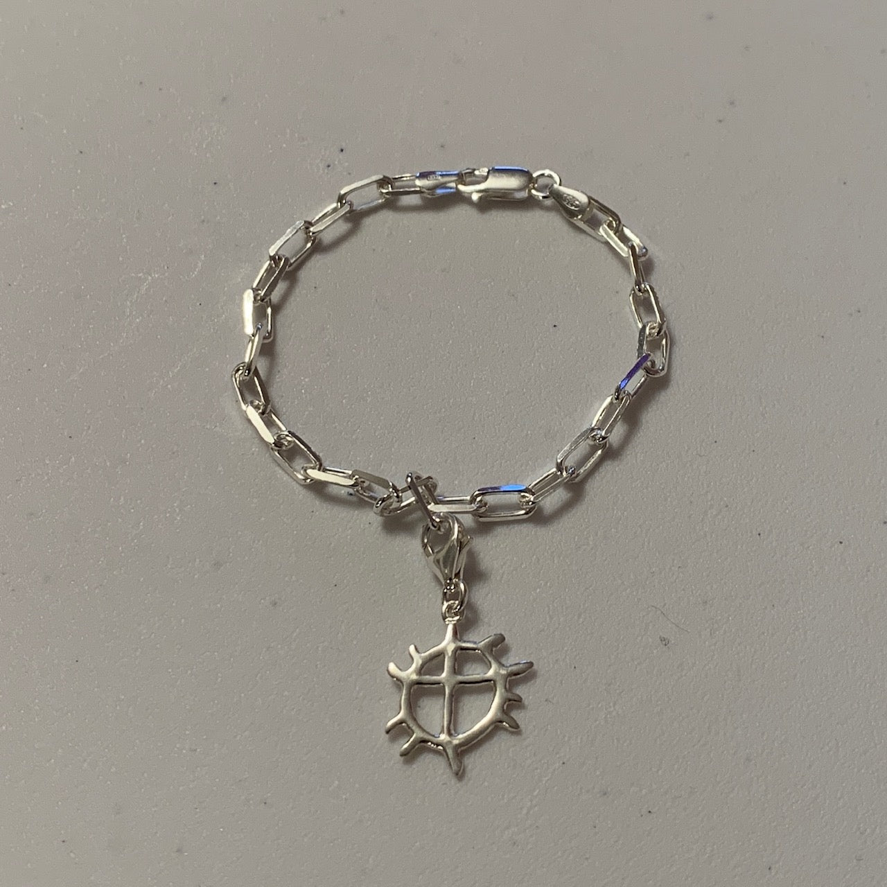 Armband i silver med samiska solen som berlock Kedjans längd är 17,5 cm. Finns hos Risjfells Sameslöjd i Vilhelmina