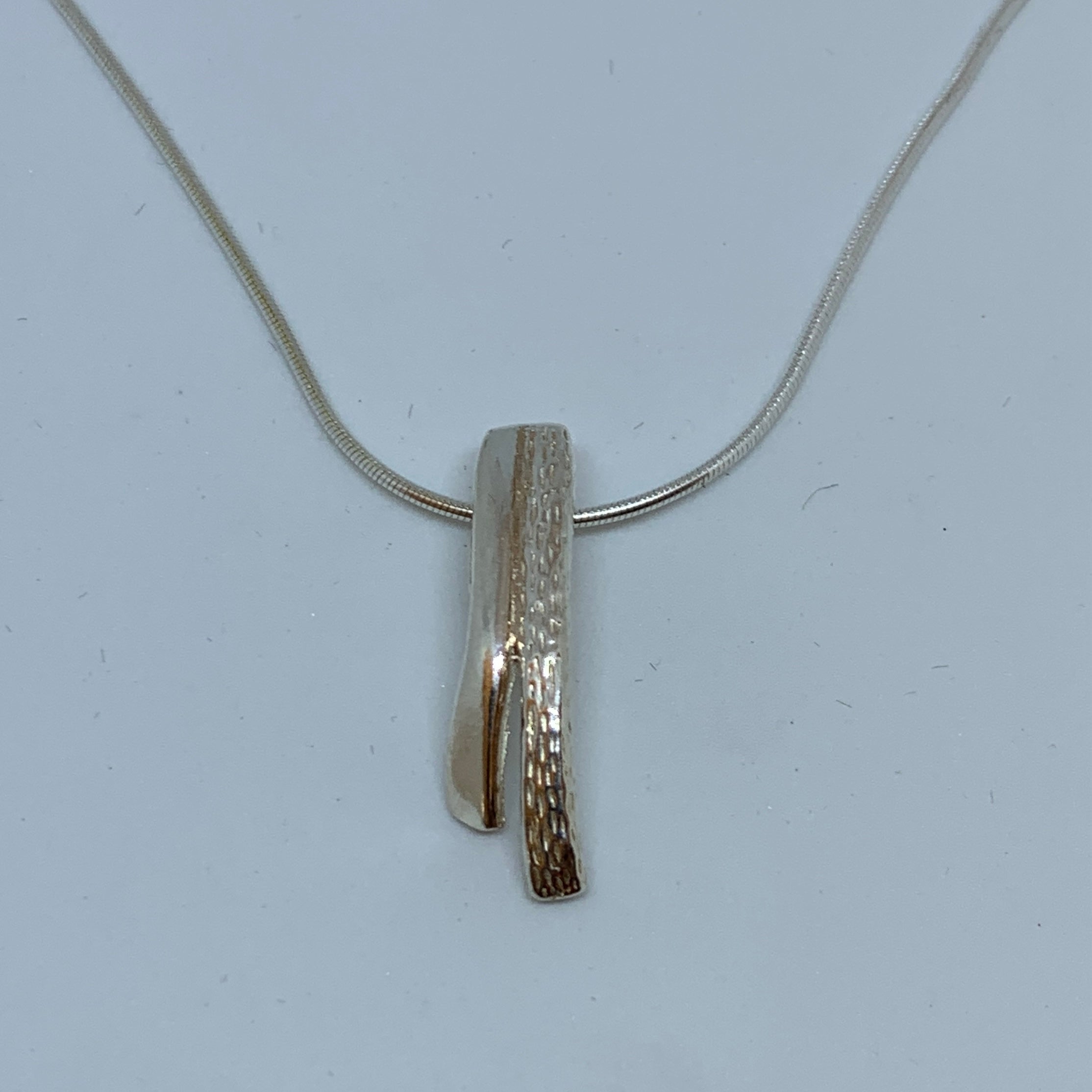 Halsband i silver Storforsen. Längd 27 mm bredd 8 mm där det är som bredast. Silverkedja 45 cm. Finns hos Risfjells Sameslöjd, Vilhelmina i södra Lappland.