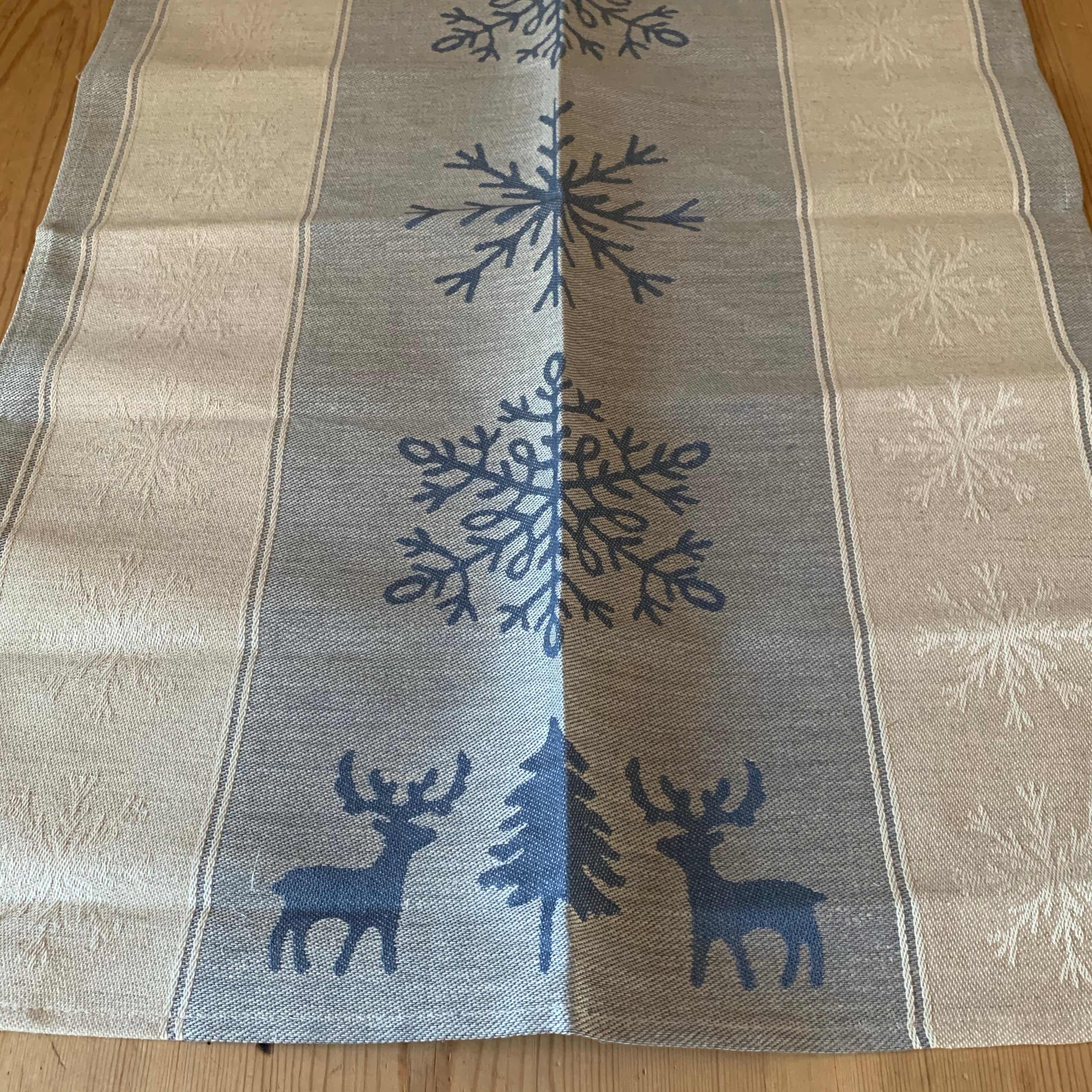 Från vår present och hemslöjdsavdelning. Handduk i lin och bomull med vackert vintermotiv snöstjärnor och renar i blått och vitt. Längd 70 cm och bredd 47 cm.