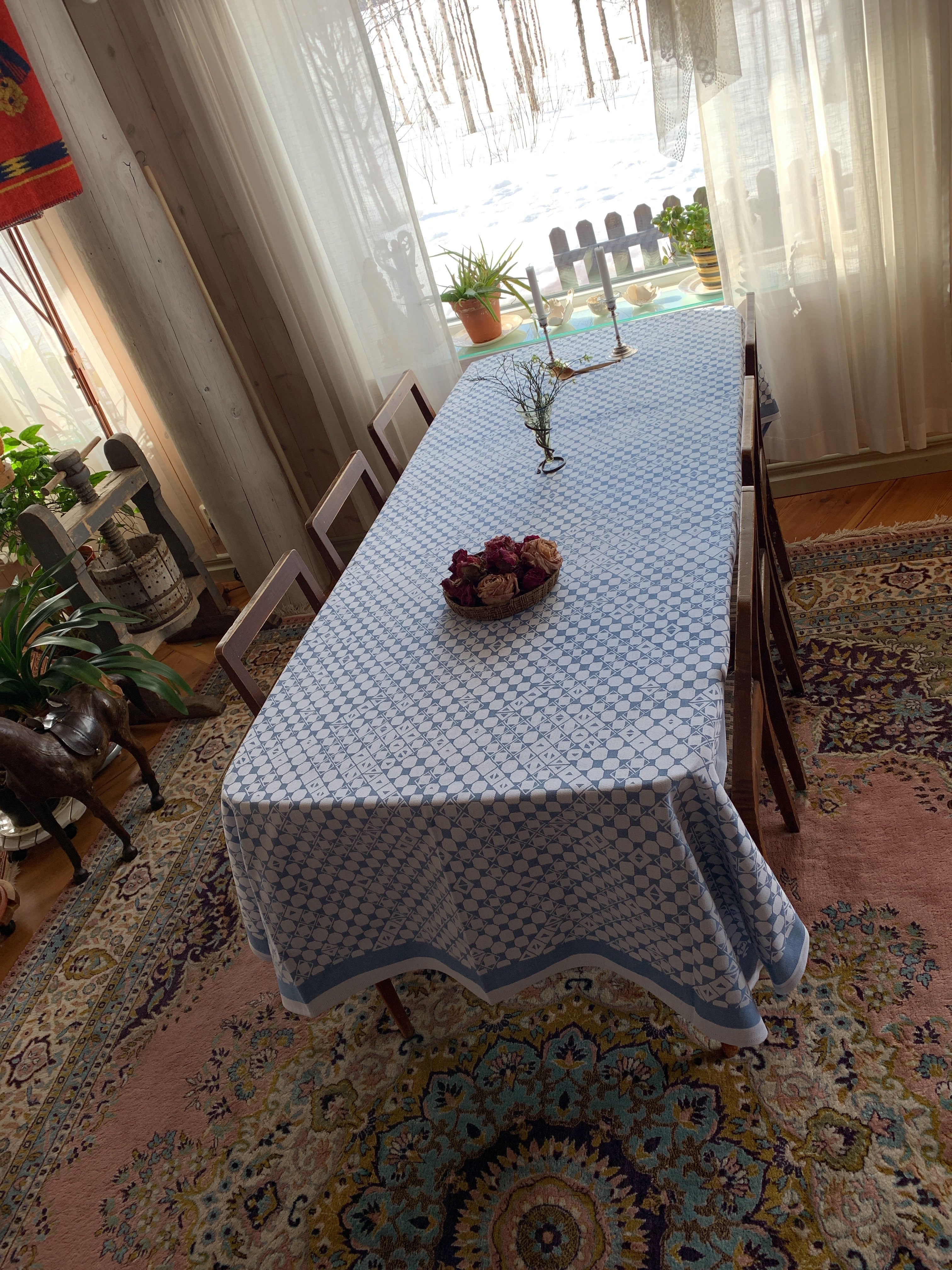 En bordsduk 150x250 cm en unik produkt från oss Risfjells Sameslöjd. Bordsduken här i blått har ett unikt sydsamiskt mönster som finns på en gammal väska (Daaskoe)som bars av sista nåjden från Marsfjäll i Vilhelmina. Sameslöjdare Sven-Åke Risfjell hittade väskan i museigömmorna 1999 och har sedan dess återbördat mönstren som fanns ingraverade på väskan i sin egen slöjd. 